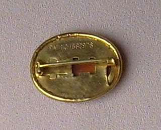 Brass (gold color) brooch with an open C pin clasp.